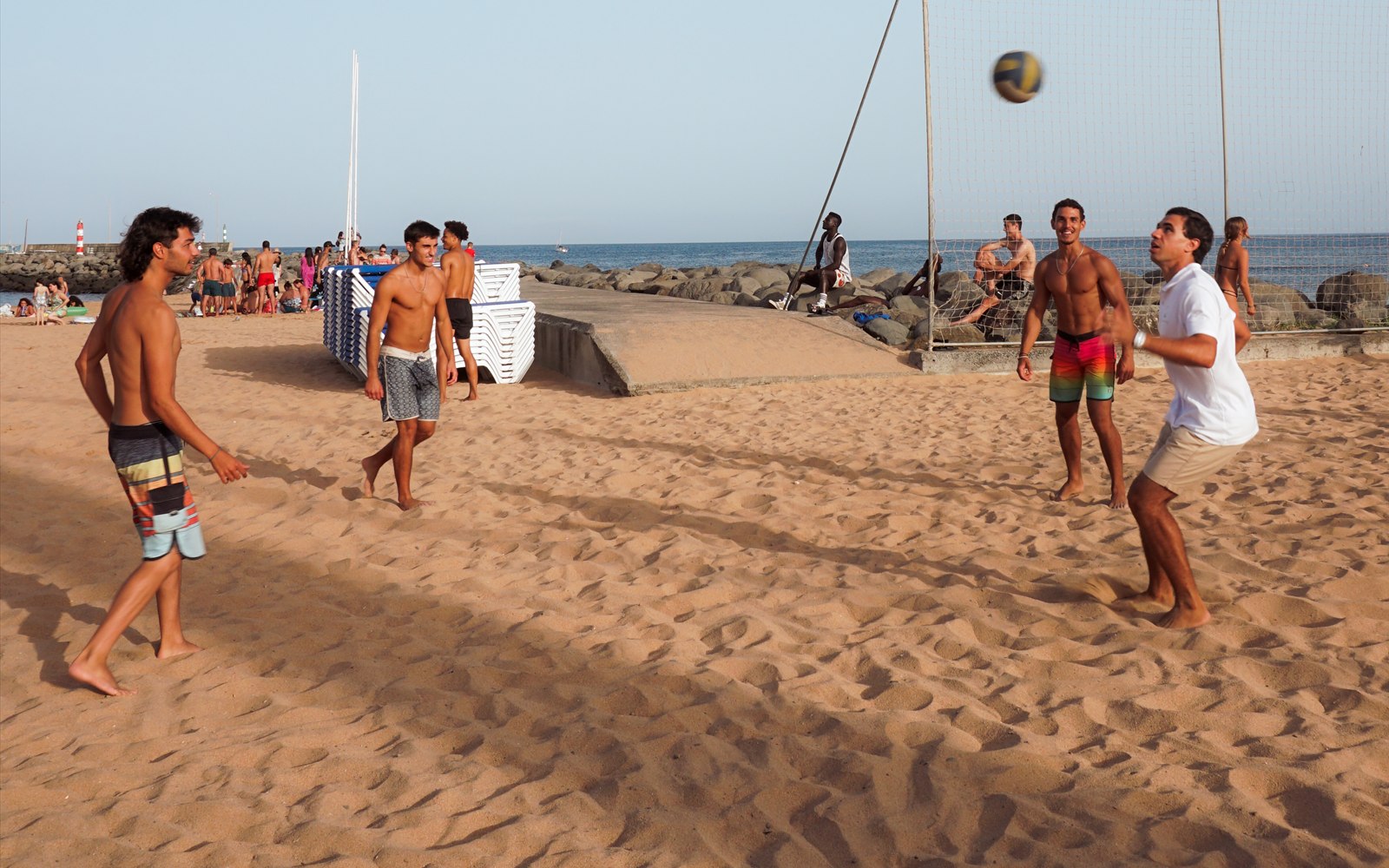 Pessoas a jogar futebol na praia de Machico